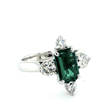 Emerald cut emerald solitaire and triangle cut diamonds, White Gold band.