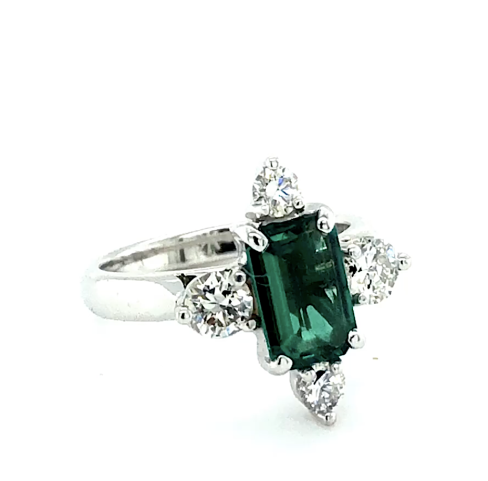 Emerald cut emerald solitaire and triangle cut diamonds, White Gold band.