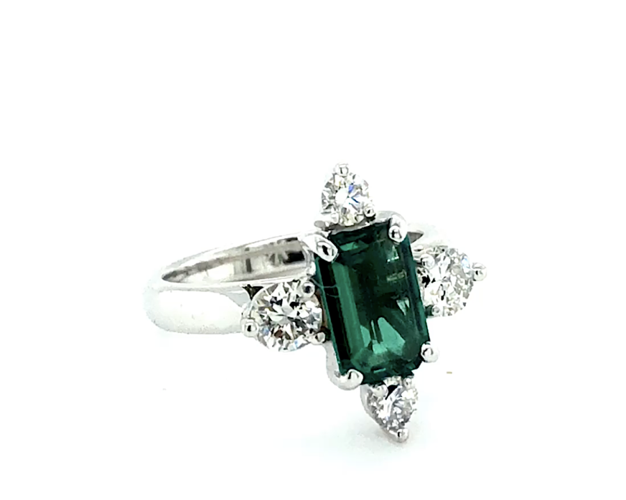 Emerald cut emerald solitaire and triangle cut diamonds, White Gold band.