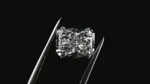Sparkling radiant cut diamond held by tweezers